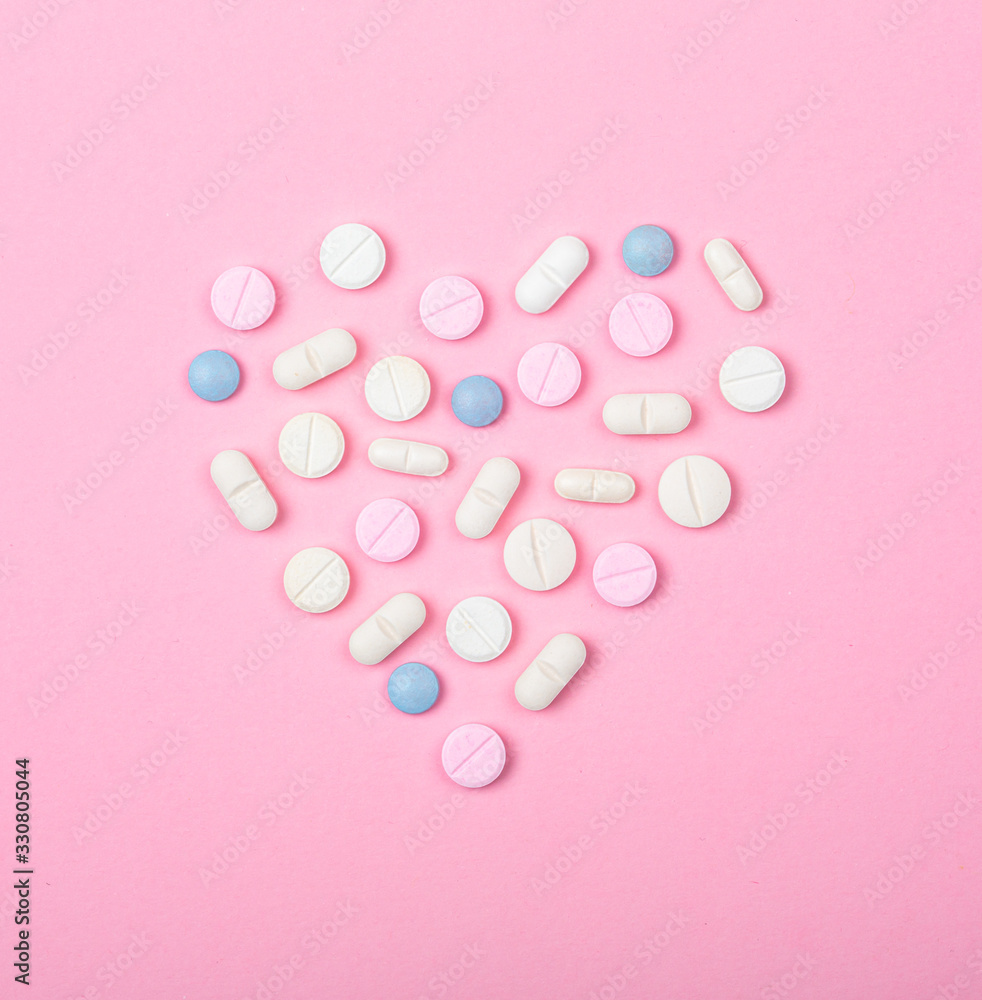Ensemble de pilules en forme de coeur sur fond rose