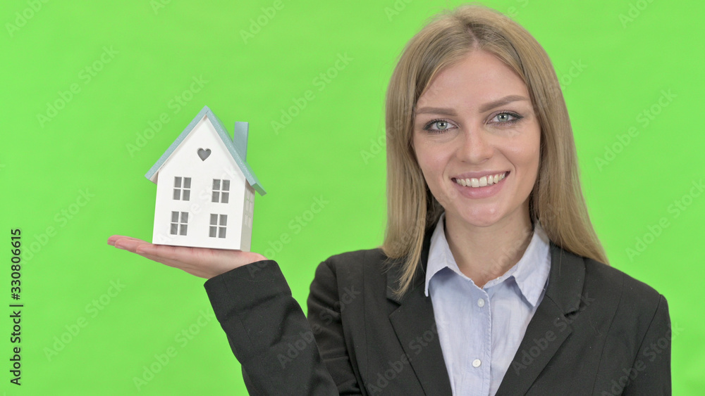 Young Businesswoman holding Model House against Chroma Key Young Businesswoman holding Model House against Chroma Key