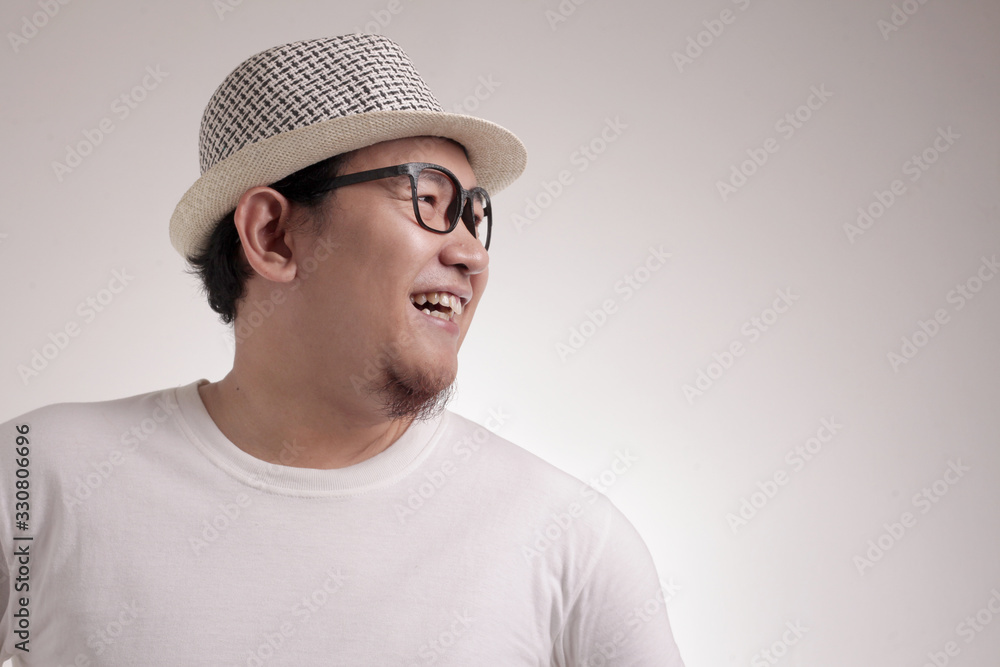 Young Asian Man Smiling Happily, Looking to the Side Young Asian Man Smiling Happily, Looking to the Side