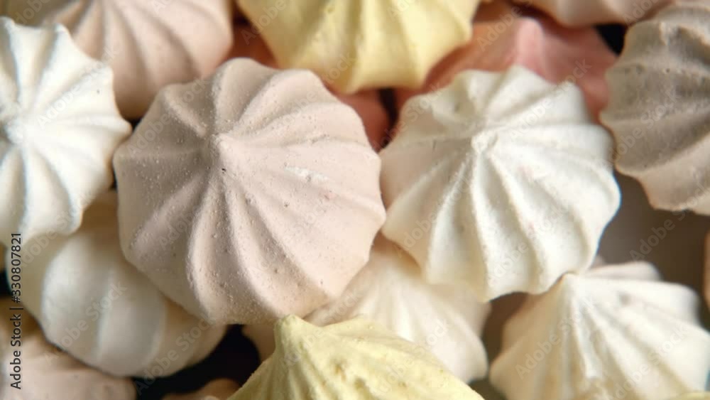 Freshly made colorful baby meringue cookies rotating, close up. Freshly made colorful baby meringue cookies rotating, close up.