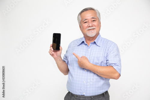 Portrait of a Asian senior man showing or presenting mobile phone application and pointing finger to smartphone on hand isolated over white background, Asian Thai mature model