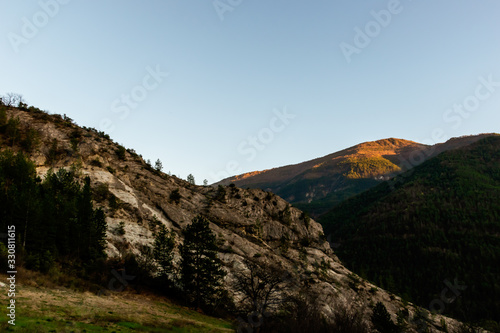 A mountain range illuminated by warm sunlight during the early sunset (French Alps)