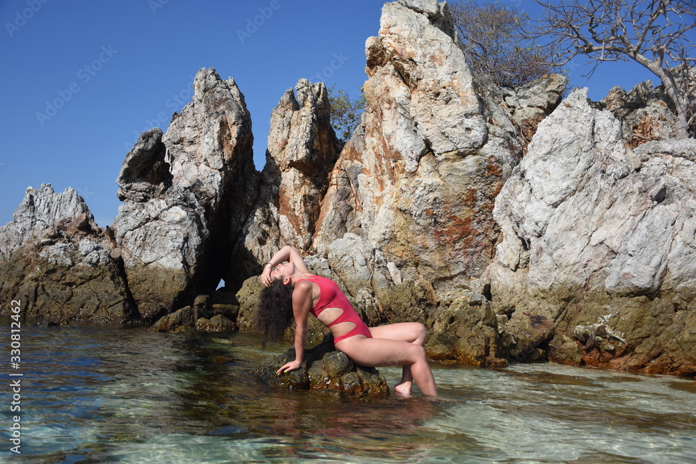 Girl on the rocky beach of the azure sea of Thailand Girl on the rocky beach of the azure sea of Thailand