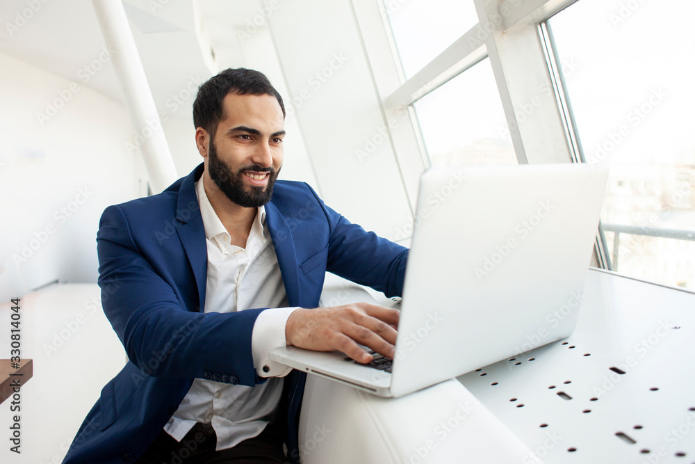 successful businessman use a laptop in the morning at cafe, a freelancer is sitting with a computer in a white office successful businessman use a laptop in the morning at cafe, a freelancer is sitting with a computer in a white office