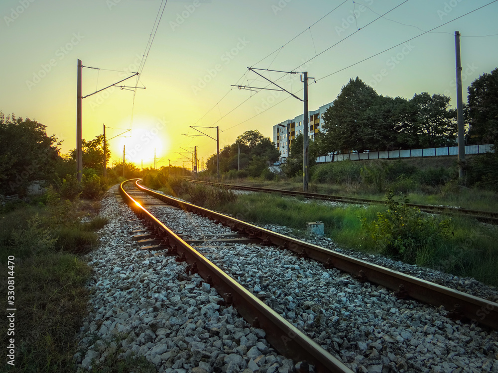 An old railroad, surrounded by nature, beautifully lighted by the sunset.
