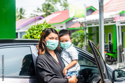 Asian mother and son using face mask as protection of Corona virus or Covid - 19 virus outbreak 
