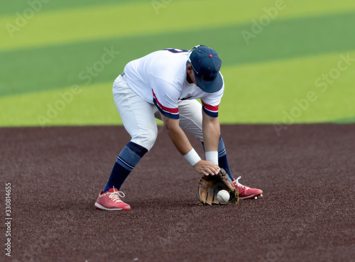 Young Boy catching and throwing the ball during a competitive baseball game
