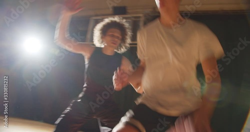 Close-up basketball game two guys dribbling wrestling standoff ball basket evening night training photo