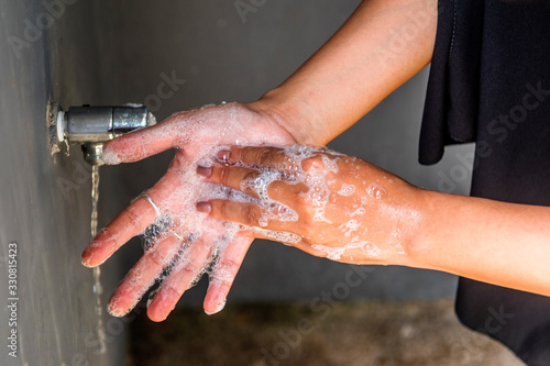 Female washing hands with soap to prevent Corona virus or Covid-19 spread
