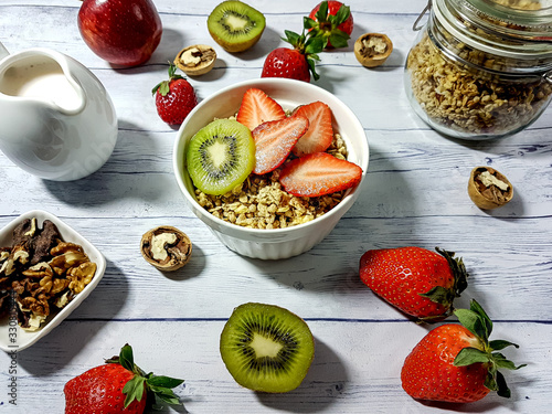 Healthy Food. Delicious granola breakfast with yogurt, kiwi, strawberries and nuts.