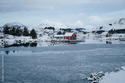 Red cabin built in traditional nordic style located in northern Norway. House stays on the bank of the ocean. Very simple architecture match with the surrounding natural landscape.
