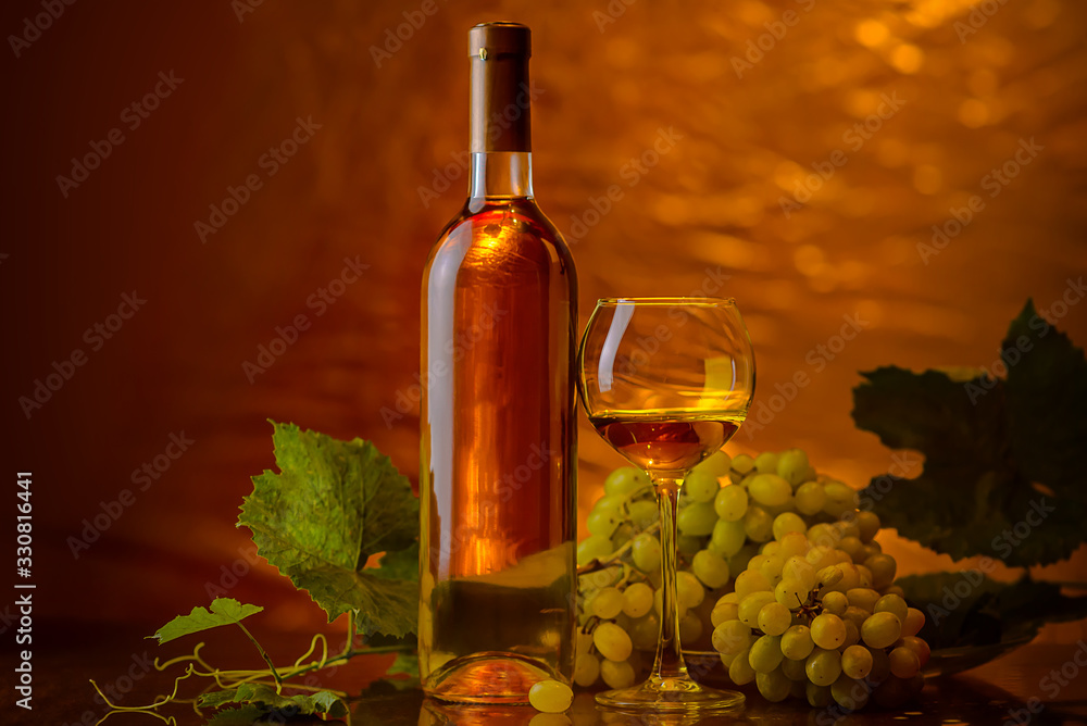 Fototapeta premium Wine. A bottle and glass of white wine with a bunch of ripe white grapes