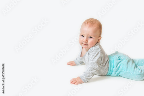 Side view of lying cute little baby boy looking at the camera. All on the white background