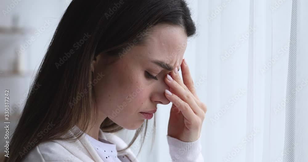 Depressed worried beautiful young woman feeling nervous, upset about problem. Anxious sad doubtful girl reflecting, looking through window and thinking of mental stress concept. Close up side face Depressed worried beautiful young woman feeling nervous, upset about problem. Anxious sad doubtful girl reflecting, looking through window and thinking of mental stress concept. Close up side face
