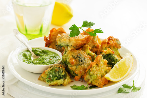 Foto Fried broccoli in batter with green sauce. Selective focus