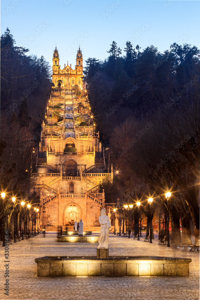 Naklejka premium Sanctuary of Nossa Senhora dos Remédios and monumental staircase in Lamego, Portugal, seen from the bottom of the staircase at dusk with the lighting on.