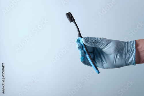 Dentist holds a toothbrush in his hand, on a blue background