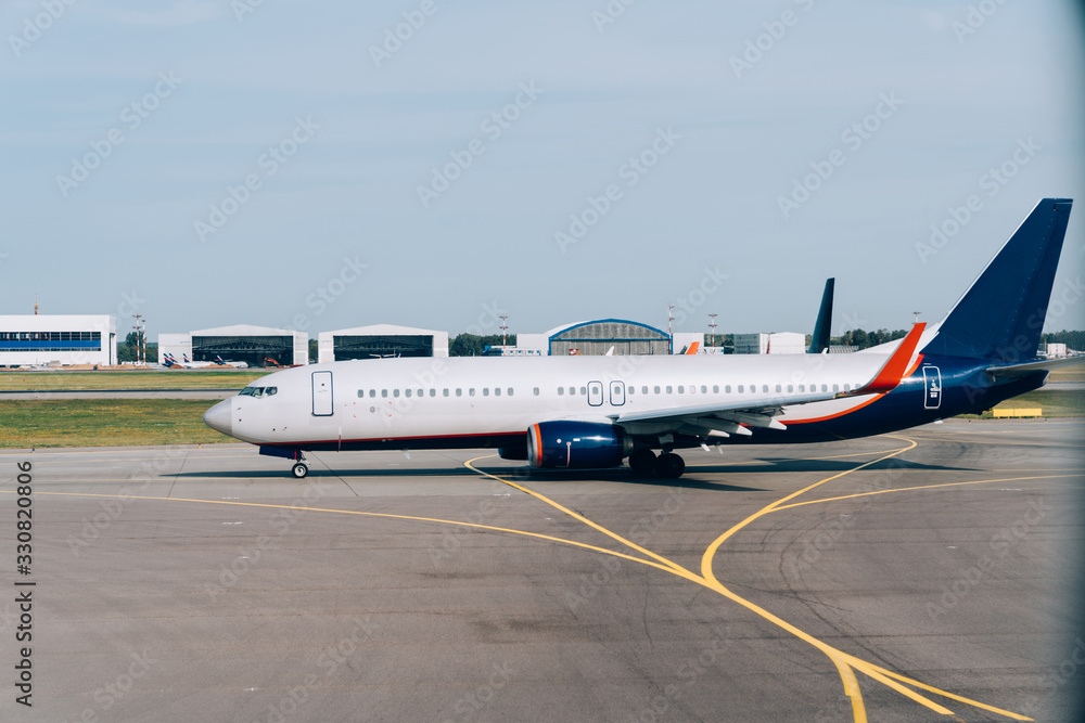 Obraz premium Side view of modern lowcost boeing waiting for take-off permit in airport terminal, international commercial vehicle parking during voyage check in, jet airliner for passengers transportation