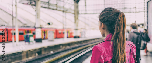 Train commuter woman going to work waiting for delayed tramway at station early morning panoramic banner background.