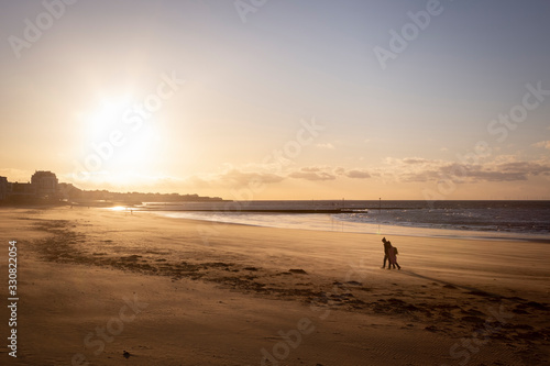 couple walking on the beach in Margate at sunset © SearchingForSatori