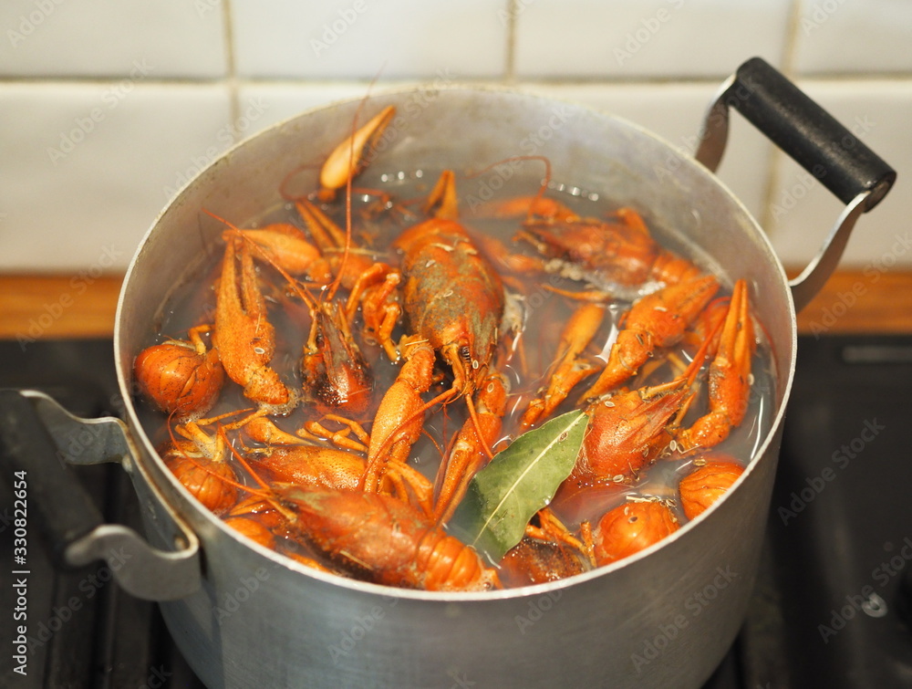Red crayfish in a pan, cooked on the kitchen stove. traditional Russian dish, natural food. Red crayfish in a pan, cooked on the kitchen stove. traditional Russian dish, natural food.