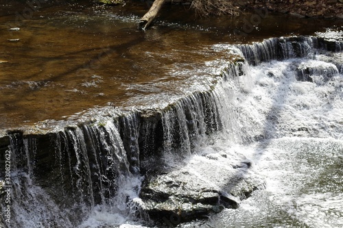 The water of the stream flowing over the rocks.