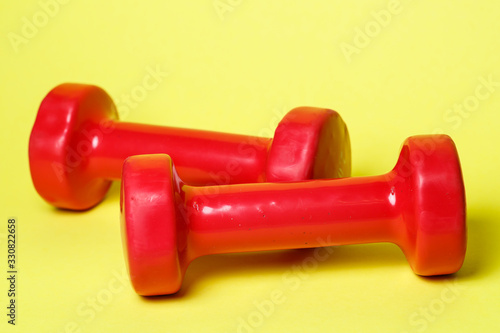 red sports dumbbells on a yellow background