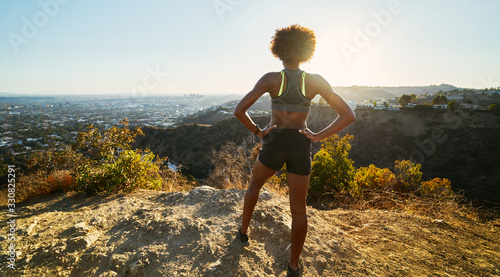 fit african american woman hiking runyon canyon stopping to see view of sunset