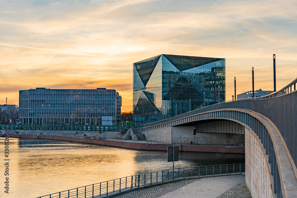 beautiful panoramic view at sunset, Berlin Spreebogen at Hugo-Preuss Bridge with a view of the Cube Berlin and John F. Kennedy House building at the main train station and the river Spree - obrazy, fototapety, plakaty 