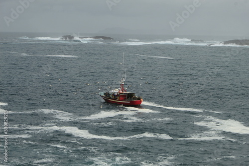 Small fishing boat, fishing near the coast, in bad weather, in La Coruña, Spain