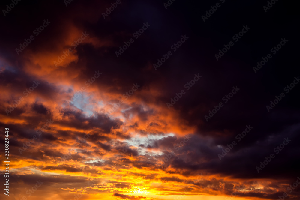 Fiery orange sunset sky with light and clouds.