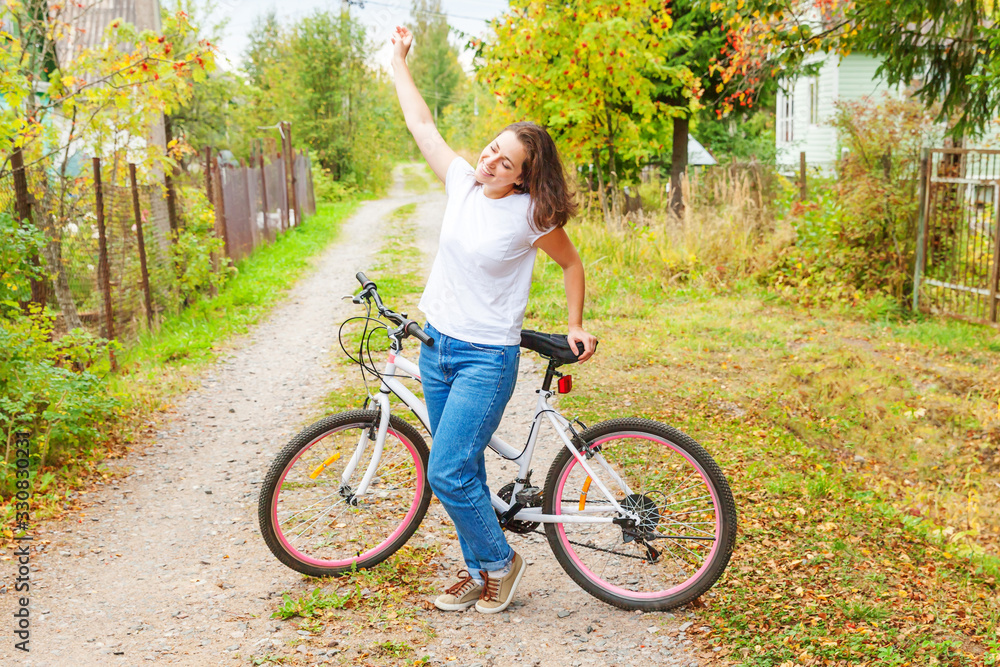 Obraz premium Young woman riding bicycle in summer city park outdoors. Active people. Hipster girl relax and rider bike. Cycling to work at summer day. Bicycle and ecology lifestyle concept.