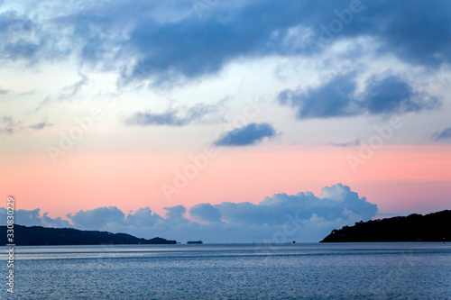 Beautiful sunrise in pink tones over the islands in the Pacific ocean, French Polynesia.