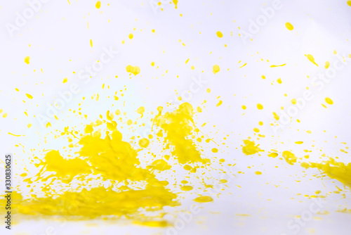 Yellow paint splatter on a white background.