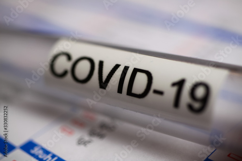 Corona virus covid-19 diagnostic, vaccination and research concept: macro closeup of isolated blood sample vial on laboratory requisition slip