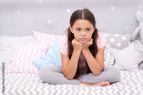 Unhappy cutie. Unhappy baby sit in bed. Little child with unhappy look. Bedtime routine. Daytime nap. Kids health. Childcare. Early morning. Good night. I cant sleep when Im unhappy