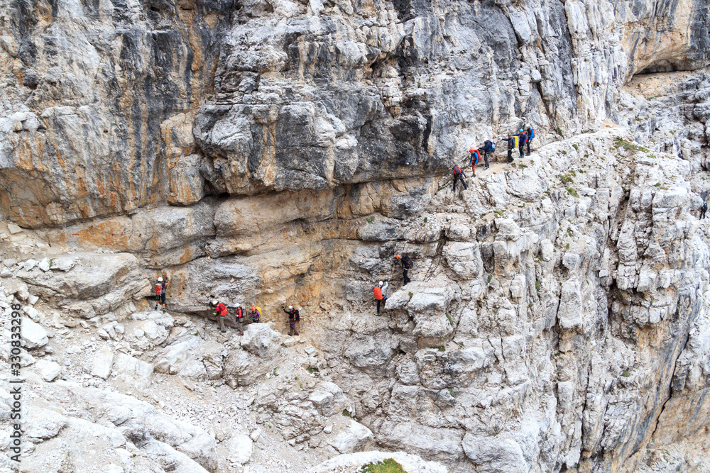 Fototapeta premium People climbing on via ferrata Sentiero delle Bocchette Centrale in Brenta Dolomites mountains, Italy