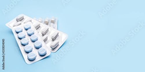 Photos Pills in blister packs on blue background. Medicine concept.