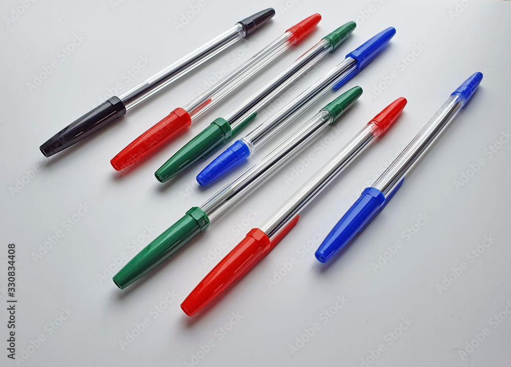 Set of plastic ballpoint pens of different colors with a plastic cover, isolated on a white background, stationery