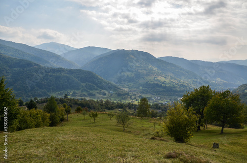 Landscape view on the beautiful hill with houses and trees in morning mountains near the Kvasy village . Summer vacation in countryside. Atmospheric rustic moment. 