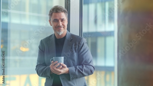 Mature businessman in office drinking coffee