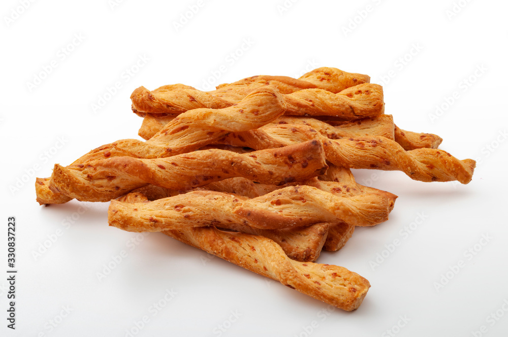 Cheesy flavor cracker, salty treat and food rich in carbohydrates group of many twisted golden cheese sticks isolated on white background Cheesy flavor cracker, salty treat and food rich in carbohydrates group of many twisted golden cheese sticks isolated on white background