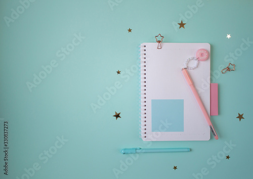 Flat layout of notepad with pink and mint accessories