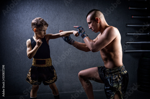 Kickboxing coach is training the boy. The concept of family, sports, mma, muay thai. photo