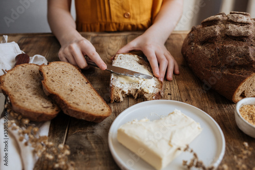 Butter is spread on a piece of rye bread