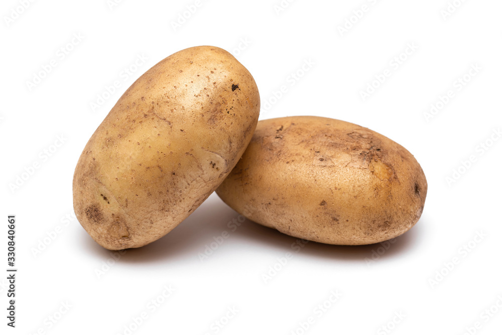 two raw dirty potatoes on a white background two raw dirty potatoes on a white background