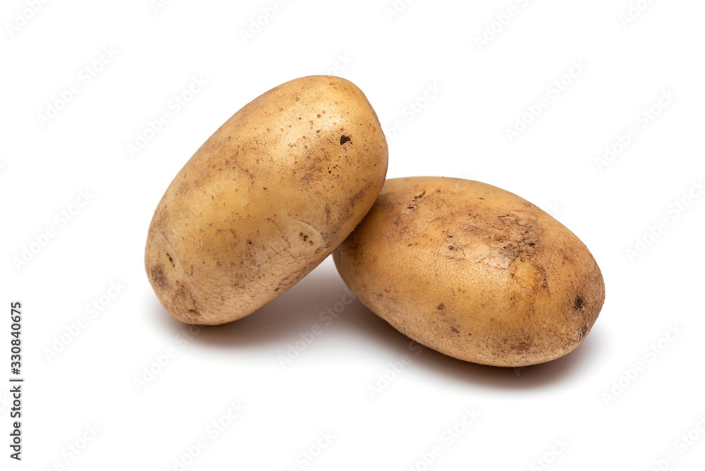 two raw dirty potatoes on a white background two raw dirty potatoes on a white background