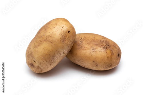 two raw dirty potatoes on a white background