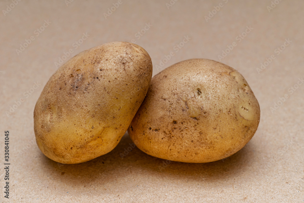 raw dirty potatoes on a craft color background raw dirty potatoes on a craft color background