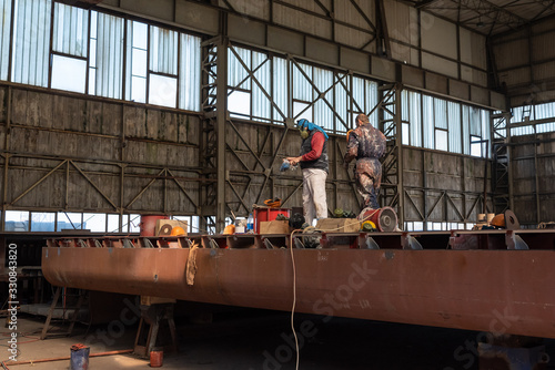 shipyard workers are working in the hangar to build a new ship